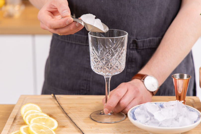 Eiswürfel ins Glas geben