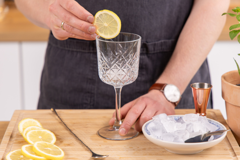 Zitronenscheibe ins Glas geben