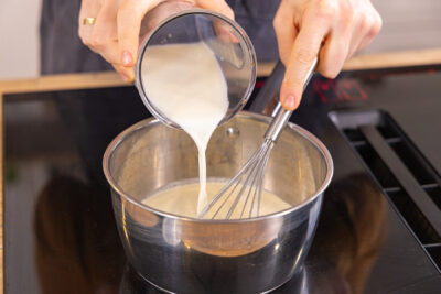 Milch in Topf gießen