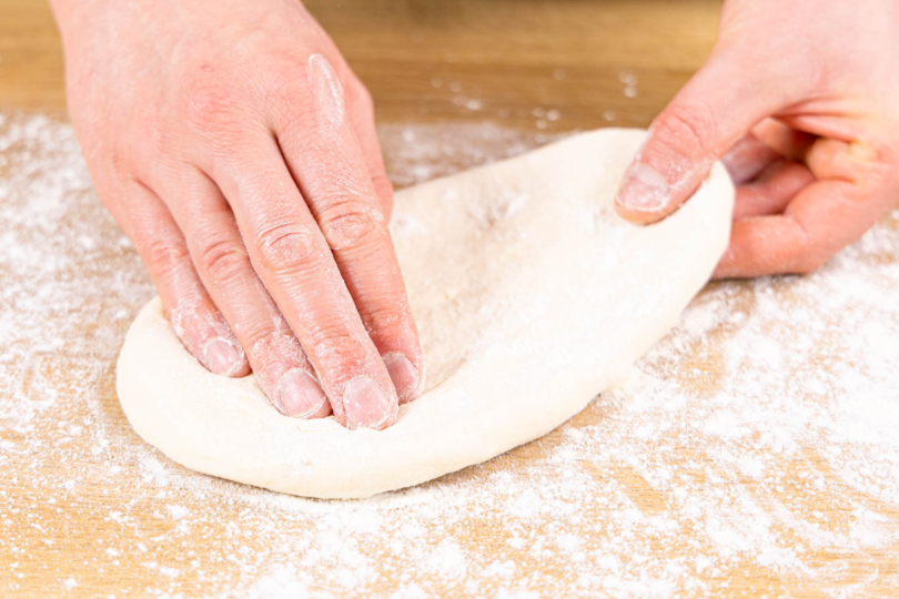 Pizzaboden mit den Händen formen