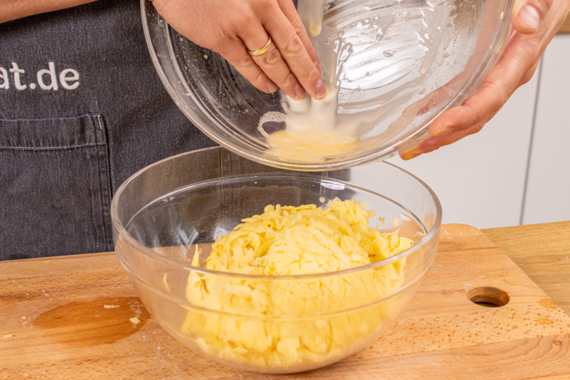 abgesetzte Stärke zu den geriebenen Kartoffeln geben