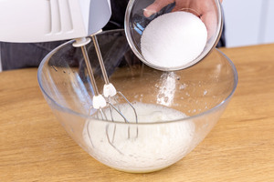 Zucker zum schaumigen Eiweiß geben