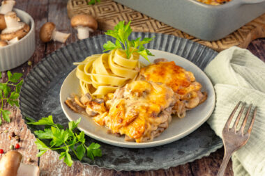 Überbackene Rahmschnitzel aus dem Ofen mit Nudeln serviert