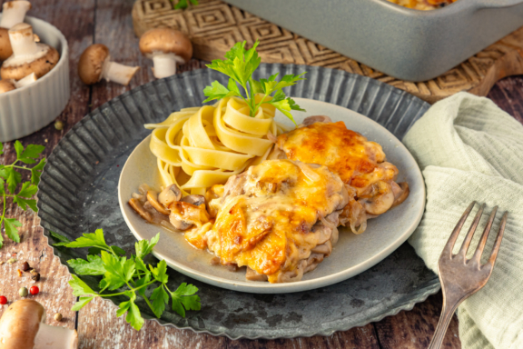 Überbackene Rahmschnitzel aus dem Ofen mit Nudeln serviert
