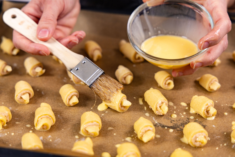 Zimthörnchen-Plätzchen mit Butter bestreichen