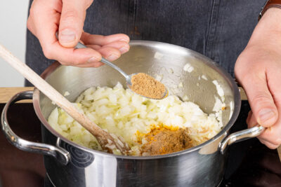 Gewürze zu den Zwiebeln geben und mitbraten