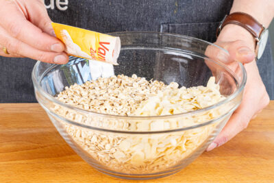 Haferflocken und gehobelte Mandeln mit Vanillezucker mischen