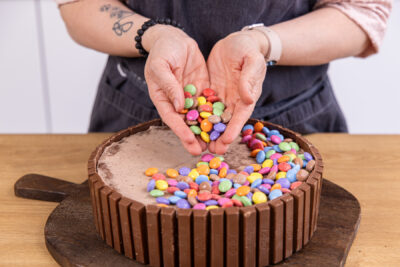 Kitkat-Torte mit buntem Smarties-Topping dekorieren