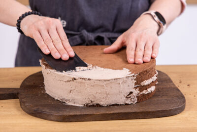 Kitkat-Torte mit buntem Smarties-Topping einstreichen