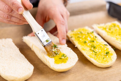 Baguette mit Knoblauch-Öl bestreichen