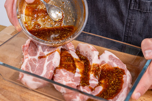 Marinade zu Nackensteaks geben