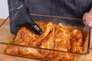 Nackensteaks mit den Händen marinieren