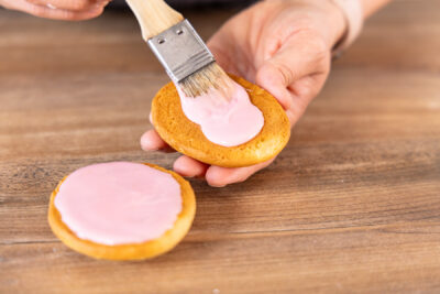 Amerikaner mit rosa Zuckerguss bestreichen