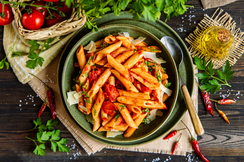 Penne al' Arrabbiata mit Kräutern und Parmesan servieren