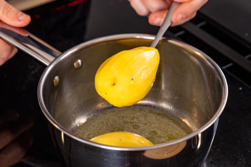 gekochte Kartoffeln in geschmolzene Butter geben