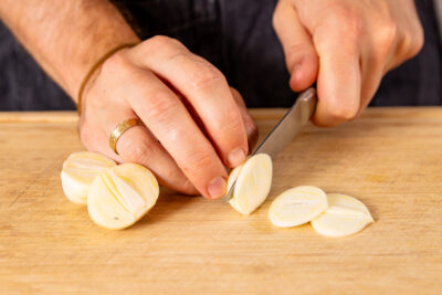 Knoblauch in dünne Scheiben schneiden