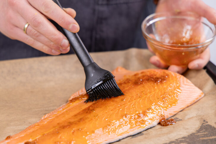 Lachs mit der Marinade bepinseln