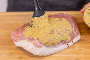 Schweinefleisch mit Senf-Kräuter-Mischung einpinseln