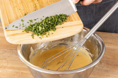 gehackte Kräuter unter die Sauce béarnaise rühren