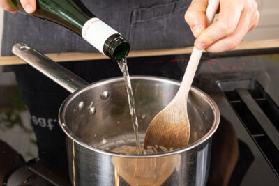 Schalotten mit Weißwein ablöschen und einreduzieren