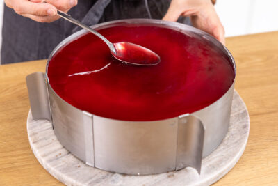 Tortenguss auf Stracciatelle-Kirsch-Torte auftragen