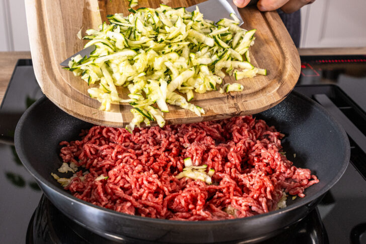 Zucchiniraspel in die Pfanne geben