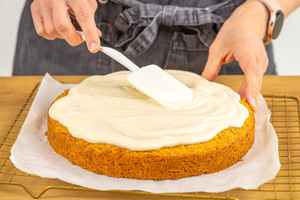 Glasur auf veganer Rublikuchen verteilen