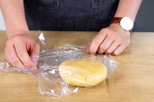 Teig in Frischhaltefolie verpacken.