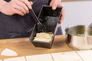 Kräuterbutter auf dem Teig verstreichen