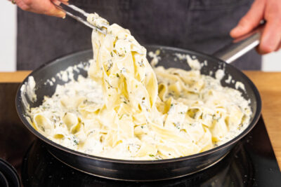 Nudeln unter die Sauce rühren und abschmecken