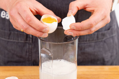 Eier aufschlagen und in Milch geben