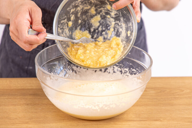 Zerdrückte Bananen für Bananenbrot-Rezept unterrühren