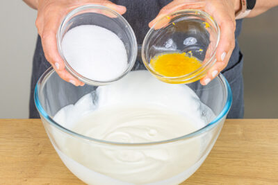 Zucker und Zitronenschale in Schüssel gießen