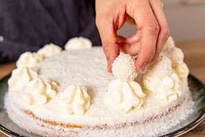 Raffaello®-Pralinen auf Sahnetuffs platzieren
