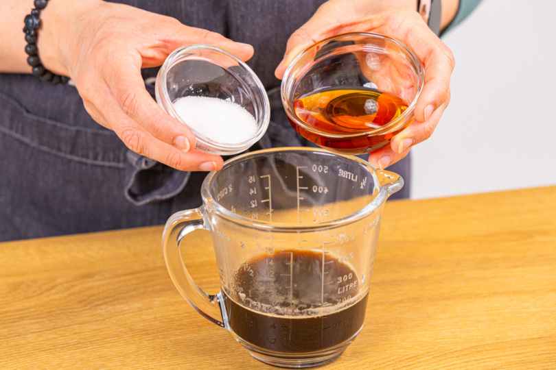 Amaretto und Zucker zu Espresso gießen