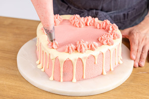 Creme auf Herztorte spritzen