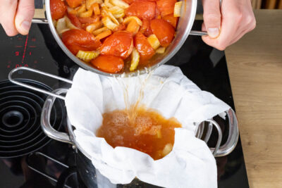 klare Tomatensuppe durch ein sieb abgießen