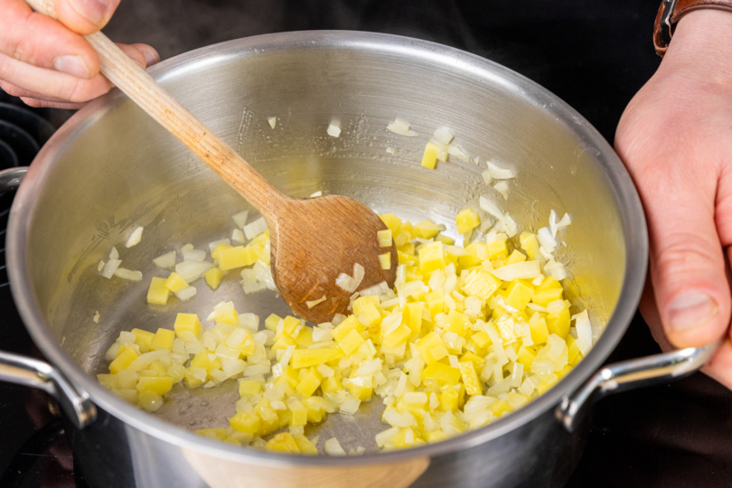 Kartoffeln- und Zwiebelwürfel in Topf anschwitzen