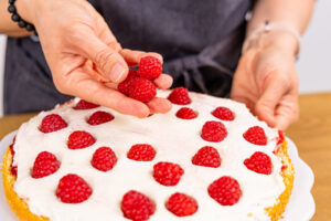 Himbeeren auf Tortencreme verteilen