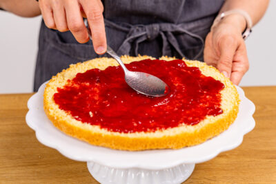 Biskuitboden mit Marmelade bestreichen