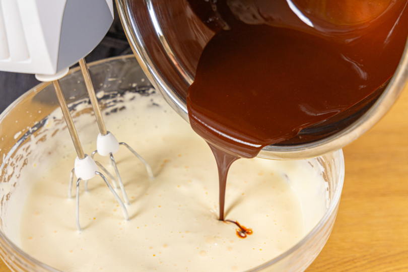 Geschmolzene Kuvertüre in Creme gießen