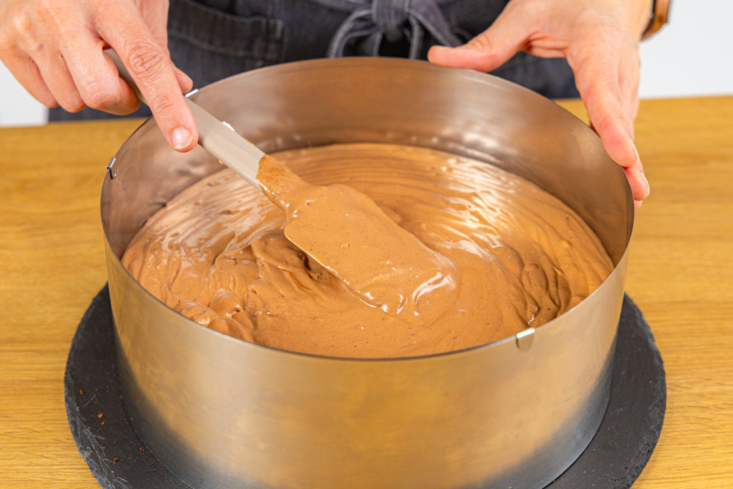 Mousse au chocolat auf Tortenboden verteilen