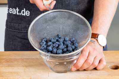 Blaubeeren über Sieb abtropfen lassen