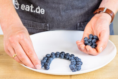Blaubeeren auf Teller im Bogen anordnen