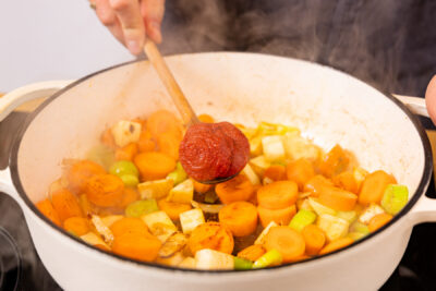 Tomatenmark zum Gemüse geben