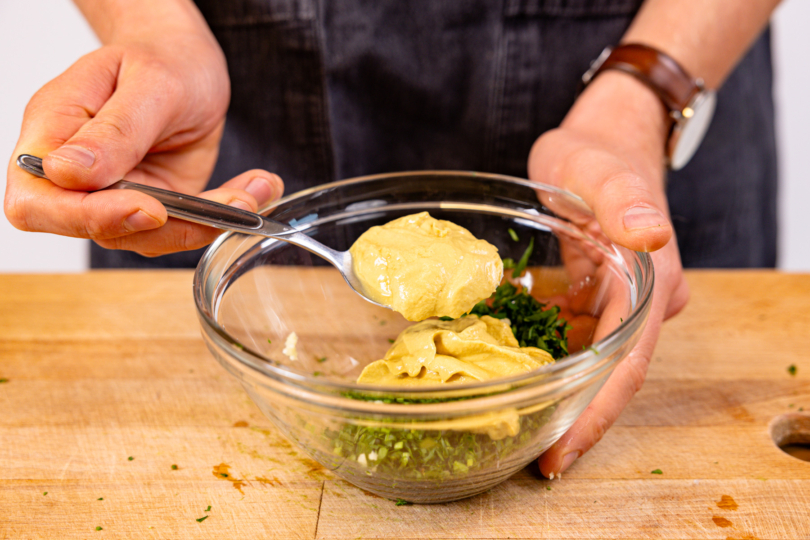 Senf zu Petersilie und Knoblauch geben