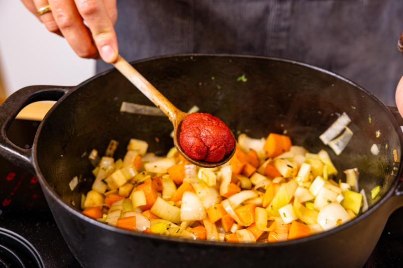 Tomatenmark zum Gemüse geben