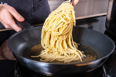 Spaghetti in die Pfanne geben