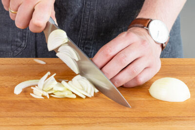 Zwiebeln un Knoblauch in Streifen schneiden