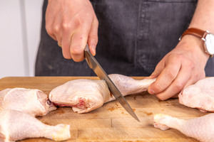 Hähnchenschenkel am Gelenk auseinander schneiden
